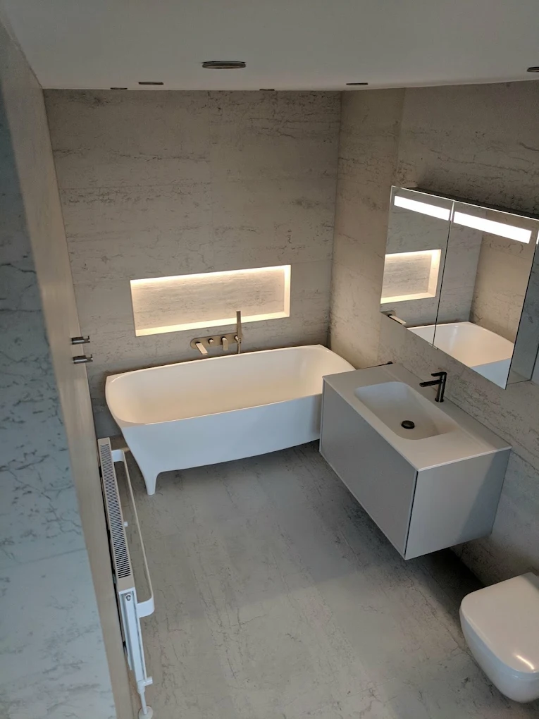 Completed bathroom installation with freestanding bath, wall-hung vanity and concealed plumbing