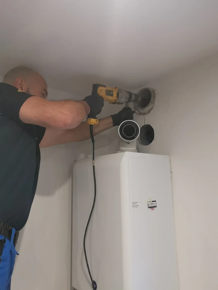 Gas Safe engineer working on a boiler flue during a service visit