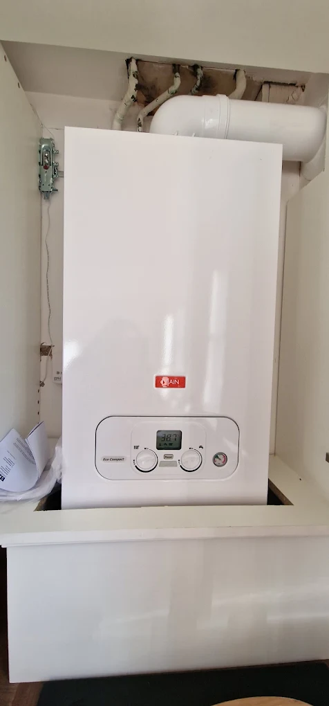 Newly installed white combi boiler fitted inside a kitchen cupboard in Liverpool